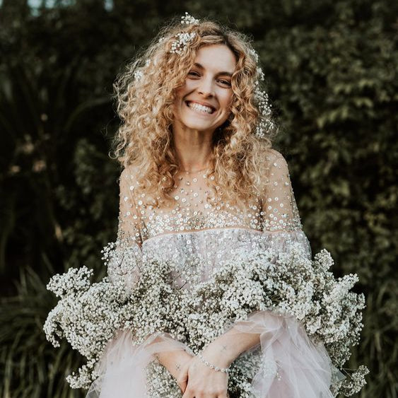 beautiful bride holding a dried flower bouquet made of dried babies breathe or gypsophila in white